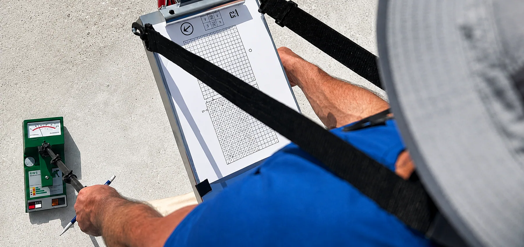 A technician recording moisture readings using a scanner and a mapping sheet